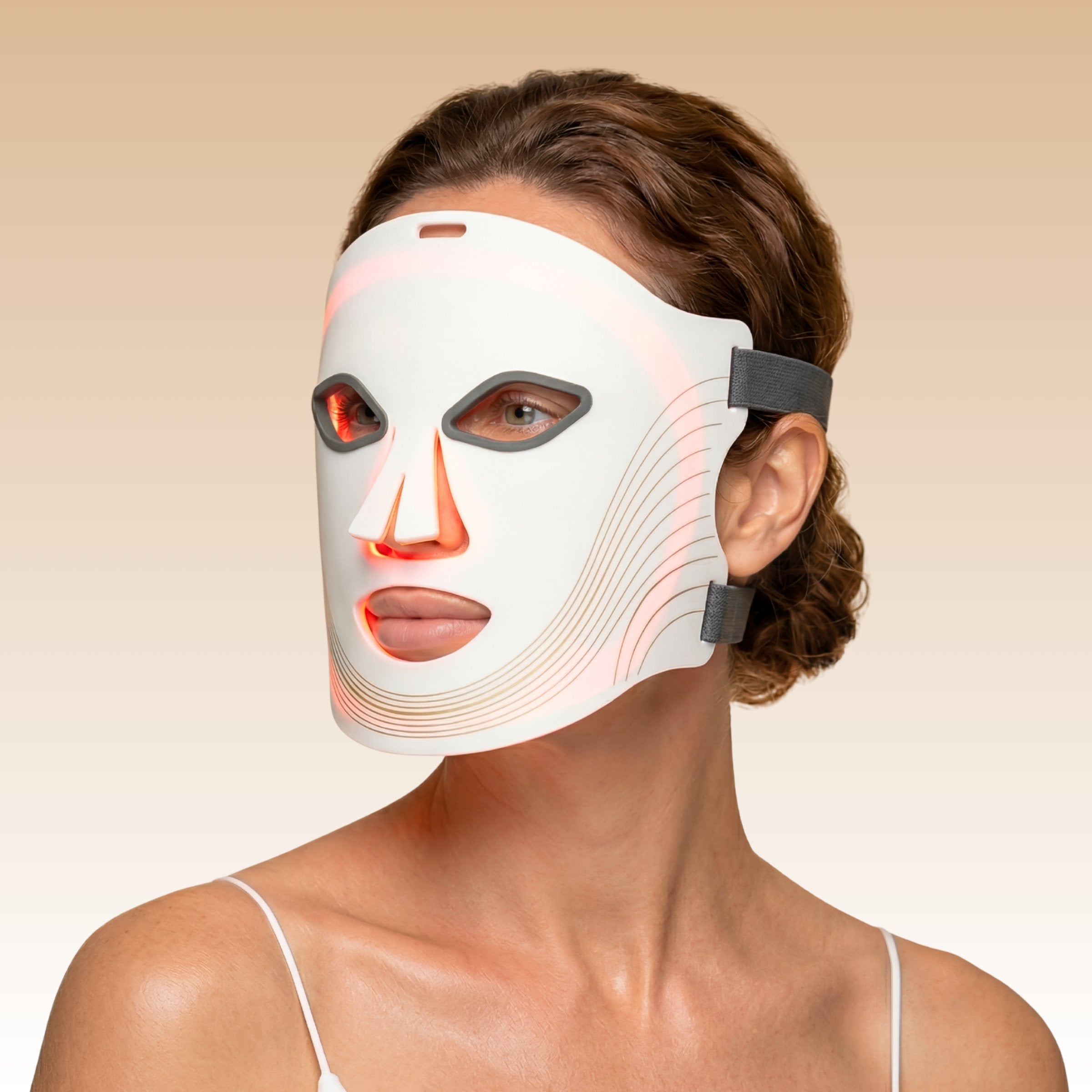 Femme portant le Masque LED visage Auréa™ blanc en silicone, lumière rouge allumée