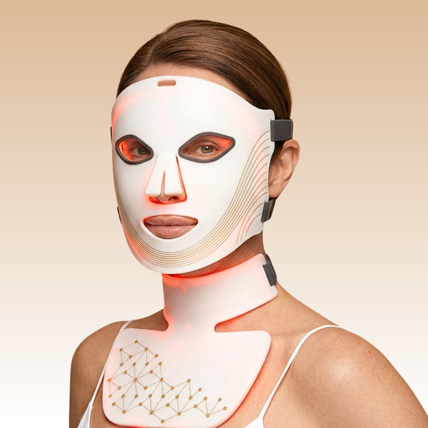 Femme portant le Masque LED intégral Auréa™ sur le visage, le cou et le décolleté, lumière rouge allumée